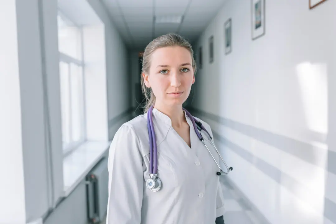 Медработник стоит в коридоре больницы